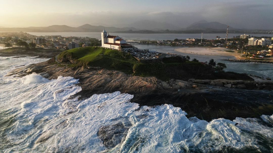 Igreja de Nazaré no costão vista de cima, com mar agitado